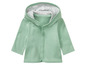 Een lichtgroen baby-vestje met capuchon.