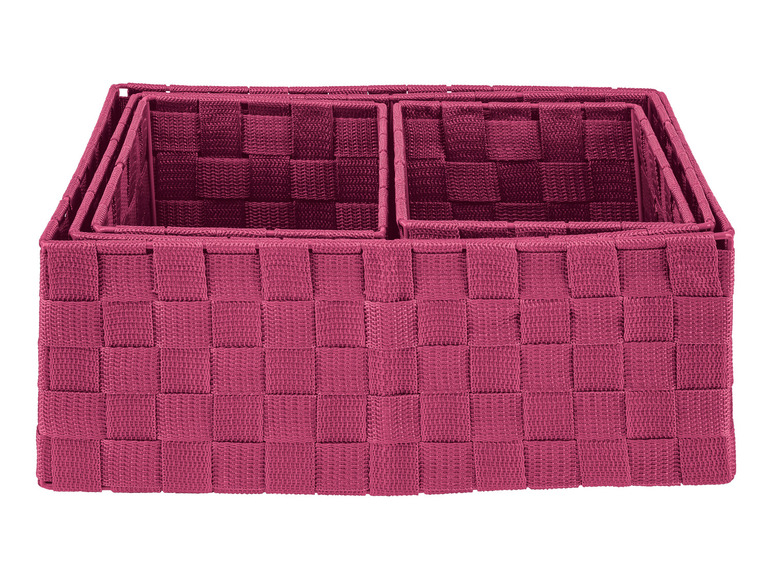 Drie roze geweven opbergmanden.