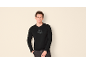 Man in zwart shirt met lange mouwen met bergprint en de tekst 'DENIM STUDIO'.