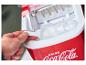 Een hand die ijsblokjes uit een rode Coca-Cola ijsblokjesmachine schept.