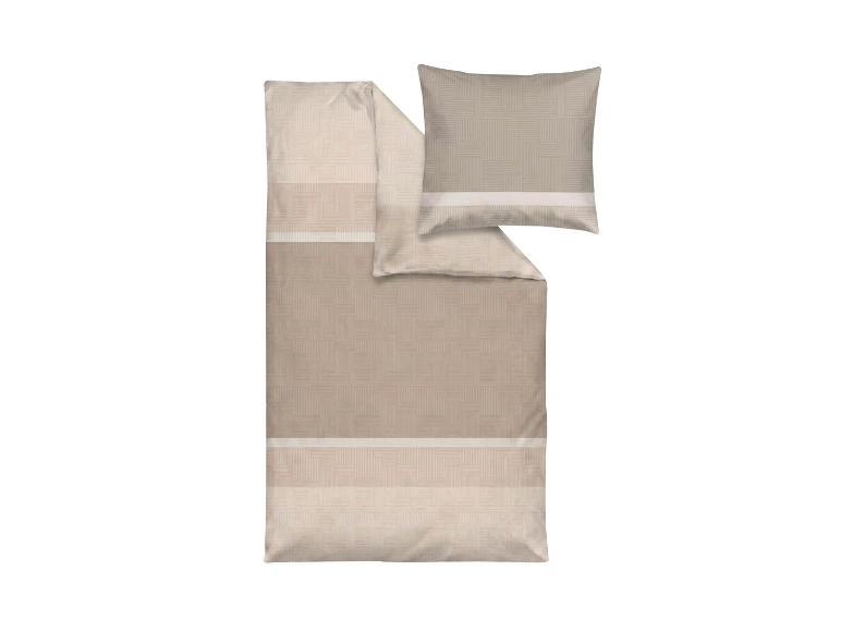 Beige beddengoed met geometrisch patroon en kussen.
