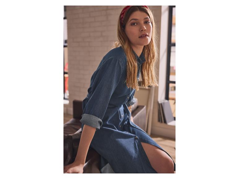 Vrouw in een jeansjurk en een rode hoofdband.