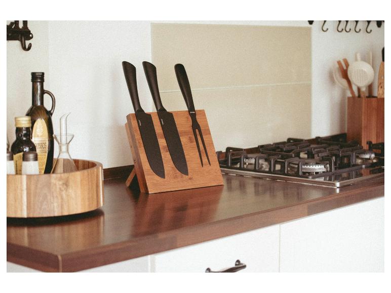 Een bamboe messenblok bevat drie zwarte J.A. Henckels messen en een snij vork.