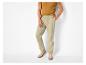 Man in mosterdgeel T-shirt en beige broek met trekkoord, beige sneakers.