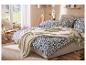 Zachte LIVARNO home deken op een bed met blauw gebloemd beddengoed.