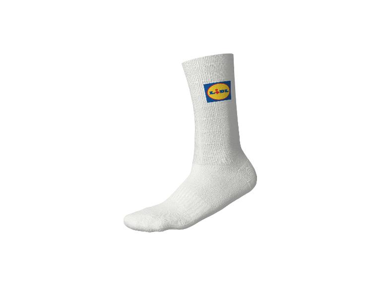 Witte sok met kleurrijk logo op gele achtergrond.