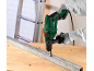 Man boort in metalen balk met boormachine op werkbank.