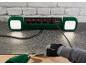 Stekkerdoos met geïntegreerde LED-lampen, gebruikt met een heteluchtpistool en schraper op een vloer.