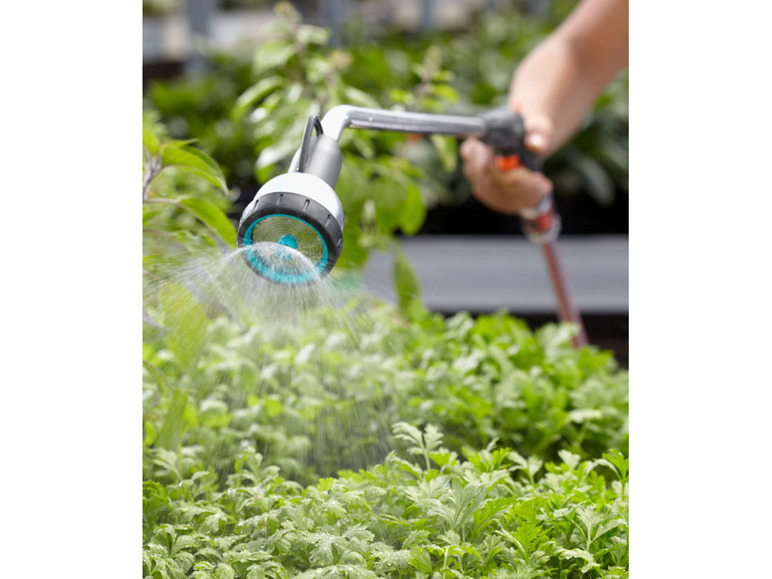 Een tuinsproeier besproeit planten met water.