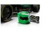 Groene racehelm en controller, met een Aston Martin raceauto op de achtergrond.