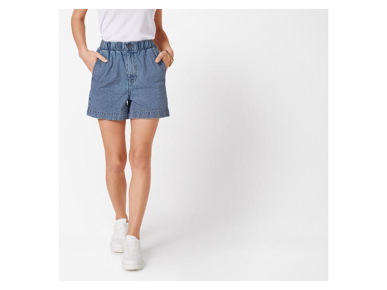 Jeans shorts en witte sneakers.