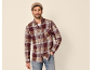 Man in geruit flanellen overhemd, wit T-shirt en jeans met muts.