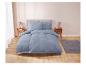 Stoftige blauwe beddengoedset op een modern bed met nachtkastjes.