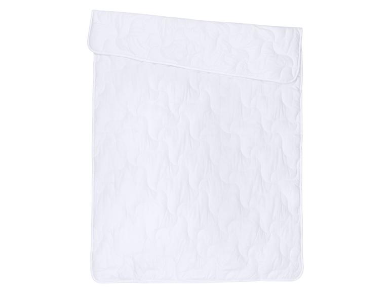 Wit dekbed met golvend patroon, bovenaan gevouwen