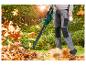 Iemand gebruikt een Parkside accu bladblazer om herfstbladeren op te ruimen.