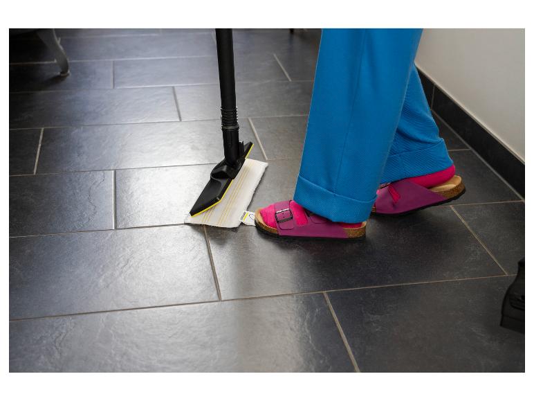 Persoon met stoommop maakt vloer schoon, draagt roze sandalen en blauwe broek.