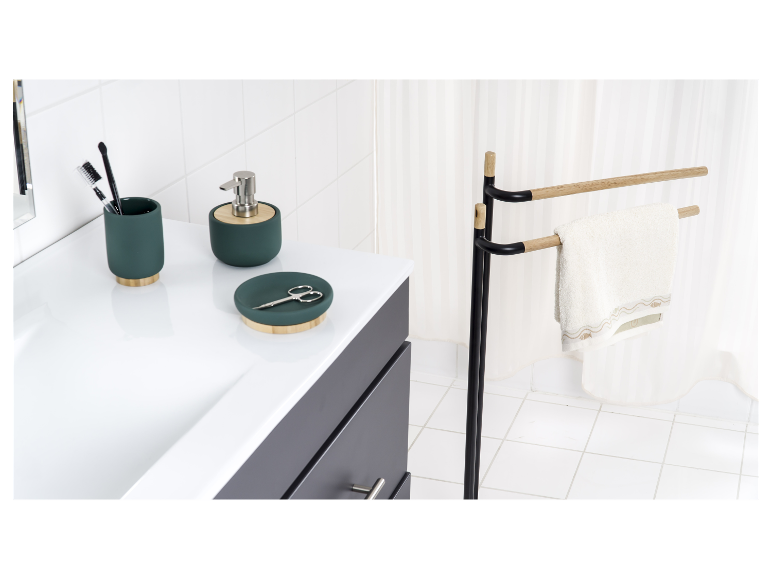 Donkergroene badkamerset met houten en metalen handdoekenrek.