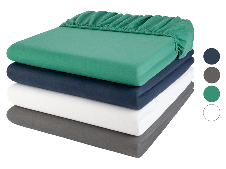 Een stapel groene, blauwe, witte en grijze hoeslakens.