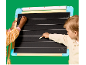 Twee kinderen schrijven met krijt op een schoolbord met lijnen om te leren schrijven.