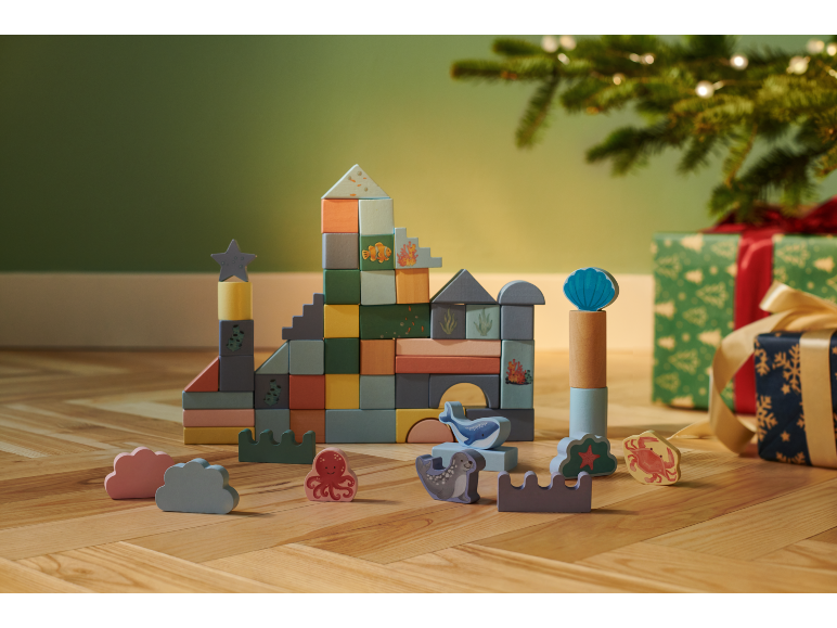 Houten bouwblokken met zeethema en dierenfiguren, met cadeaus onder de kerstboom.