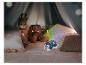 Een blauwe zeehondvormige nachtlamp projector verlicht een tent met knuffels.