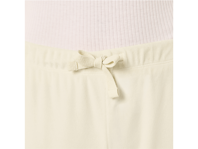 Detail van een crèmekleurige top en broek met trekkoord.