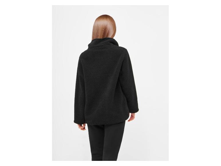Vrouw van achteren in een zwarte fleece jas en zwarte broek