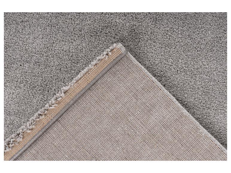 Grijs tapijt met een omgevouwen hoek die de onderkant en de rand toont.