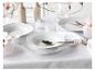 Tafeldekking met wit servies, glazen en magnoliabloesems.