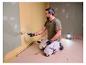 Man schildert muur, verlicht door LIVARNO® werklicht »The Painter«.