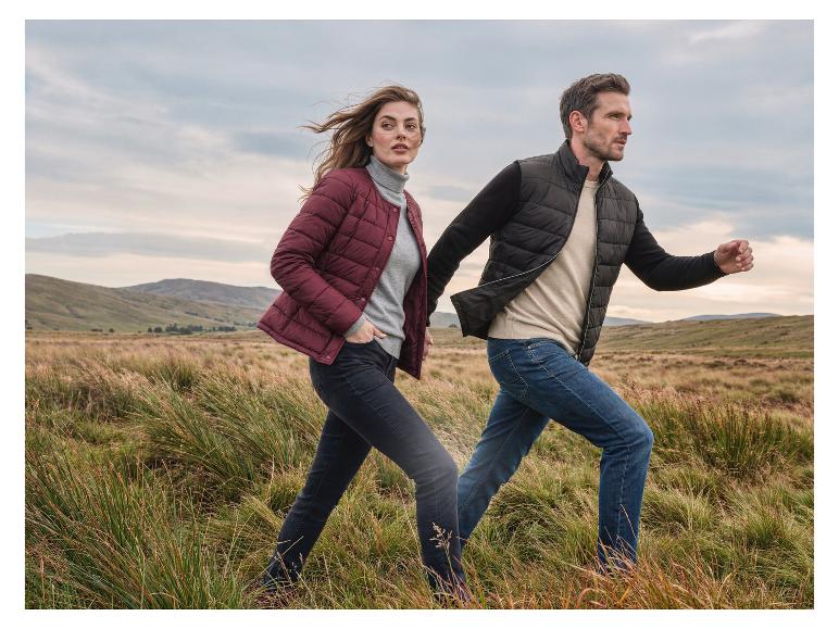 Man en vrouw in de natuur, gekleed in gewatteerde jassen en jeans.