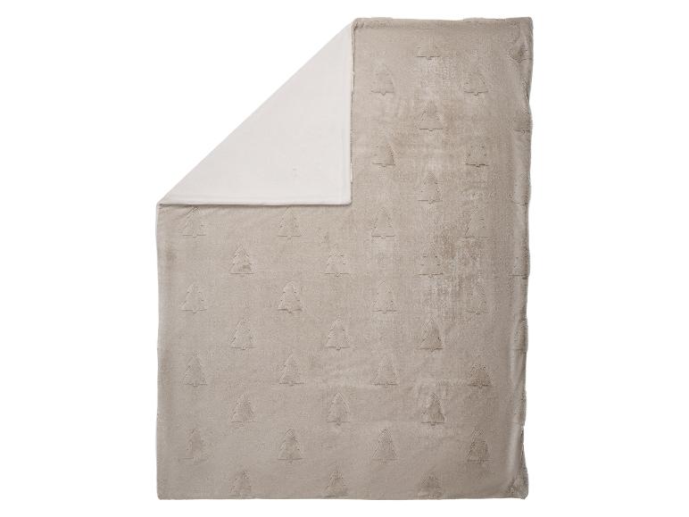 Zachte beige deken met een reliëf kerstboompatroon, met een witte kant.