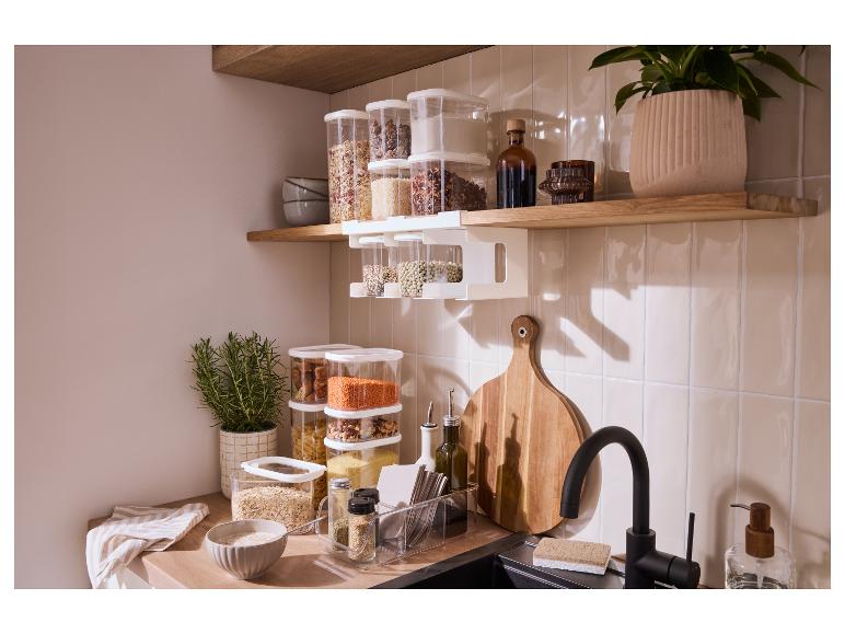 Georganiseerde keuken met houten planken, voedselopslagcontainers en keukengerei.