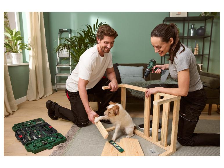 Een stel monteert meubels met Parkside gereedschap, terwijl hun hond toekijkt.