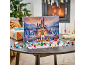 Adventskalender voor kinderen met een speelgoedkasteel en figuurtjes op een tafel voor de haard.