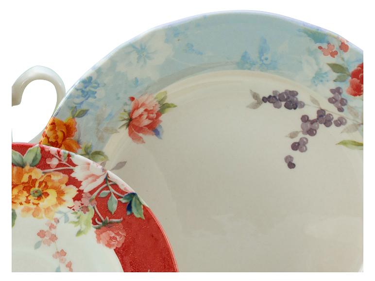 Keramische borden met bloemen- en bessenpatronen, één met een rode rand, de andere met een blauwe rand.