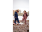 Twee kinderen in regenpakken en regenlaarzen spelen in een plas.