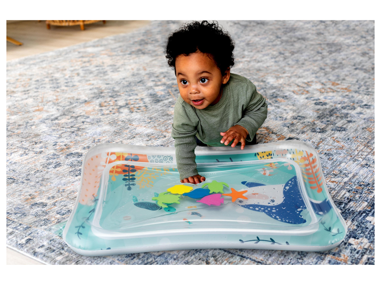 Baby speelt met een opblaasbaar watermatje met zeethema.