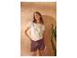 Vrouw in geborduurd T-shirt met korte mouwen en bruine shorts met trekkoord.