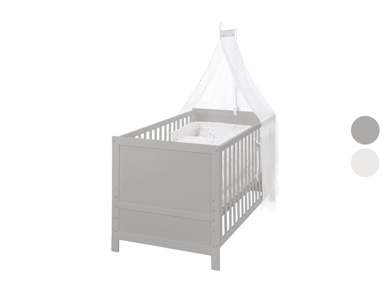 Een grijs babybed met een wit hemelbed.