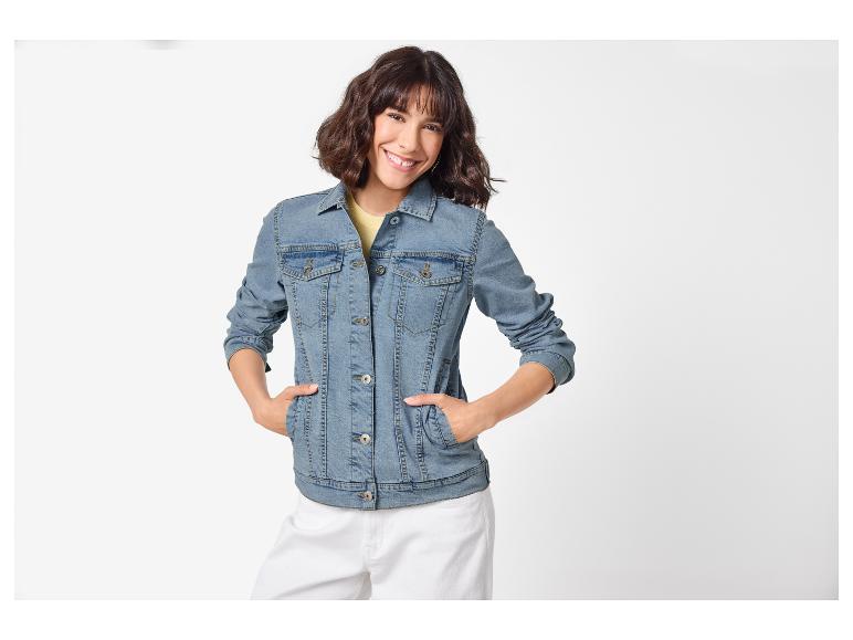 Lachende vrouw in spijkerjack en witte broek