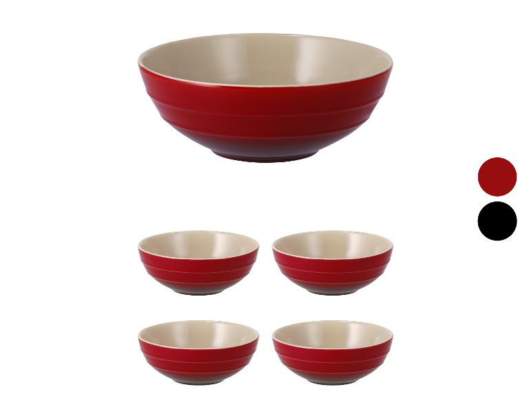 Vier rode Le Creuset kommen met een crèmekleurige binnenkant.