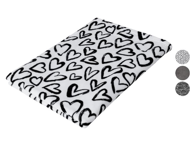 Witte deken met zwarte harten en drie ronde patroonstalen.