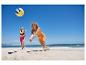 Twee vrouwen spelen volleybal op het strand.