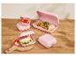 Roze lunchboxen met wraps, aardbeien, kaas en komkommer op een houten tafel.