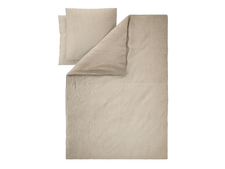 Beige beddengoedset met dekbedovertrek en twee kussenslopen van gekreukeld katoen