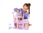 Meisje speelt met een roze poppenhuis en speelfiguren.
