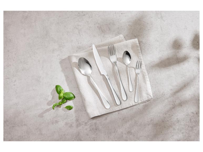 Bestek van roestvrij staal op een beige doek.