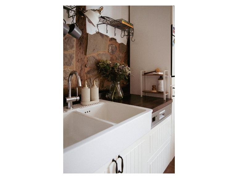 Keuken gootsteen met dubbele bakken en elegante zeepdispensers.