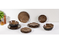 Een collectie bruin en zwart aardewerk servies, inclusief borden en kommen, met keukenaccessoires.